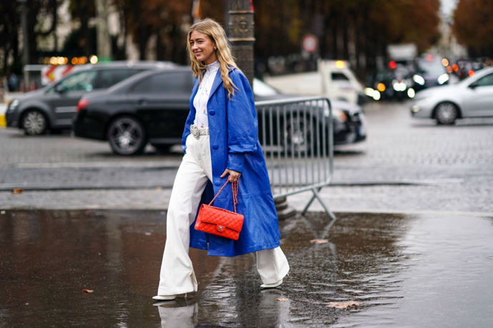 Emili Sindlev přidala červený detail v podobě Chanel kabelky k celobílému outfitu a modrému kabátu.
