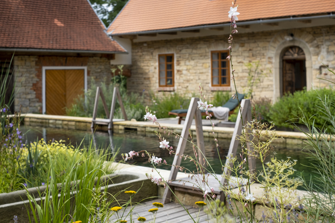 Původní statek se nachází na okraji menší vesnice u Litomyšle. Renovace se dotkla všech částí pozemku, nejvýraznější proměnou ale prošel dvůr, který je ze tří stran lemovaný budovami a z poslední se otevírá do sadu s původními i novými stromy.  Novou dominantou se stal přírodní biotop, který svou délkou uspokojí nejednoho plavce. 
