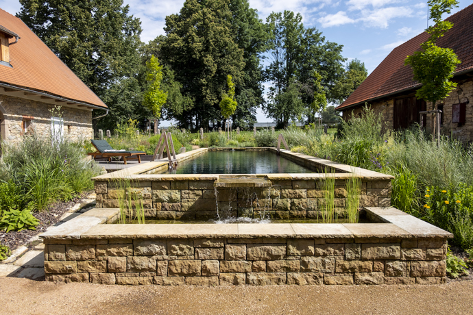 Původní statek se nachází na okraji menší vesnice u Litomyšle. Renovace se dotkla všech částí pozemku, nejvýraznější proměnou ale prošel dvůr, který je ze tří stran lemovaný budovami a z poslední se otevírá do sadu s původními i novými stromy.  Novou dominantou se stal přírodní biotop, který svou délkou uspokojí nejednoho plavce. 
