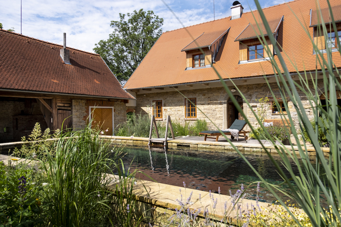 Původní statek se nachází na okraji menší vesnice u Litomyšle. Renovace se dotkla všech částí pozemku, nejvýraznější proměnou ale prošel dvůr, který je ze tří stran lemovaný budovami a z poslední se otevírá do sadu s původními i novými stromy.  Novou dominantou se stal přírodní biotop, který svou délkou uspokojí nejednoho plavce. 
