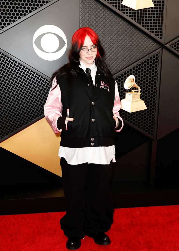 Billie Eilish opět potvrdila, že okázalé róby na červeném koberci nejsou nic pro ni. Stylistka, která mimo jiné obléká i Margot Robbie, jí vybrala bomber s růžovými rukávy a Barbie logem od značky Chrome Hearts.
