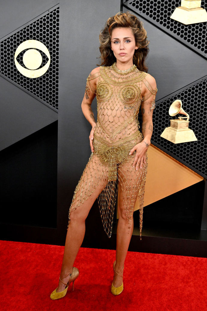 Miley Cyrus v šatech Maison Margiela vyrobených kompletně ze zlatých zavíracích špendlíků, k šatům obula lodičky Christian Louboutin for Maison Margiela. Celkem během večera zpěvačka vystřídala čtyři outfity.
