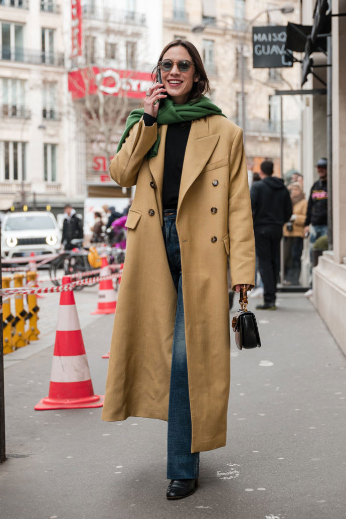 Alexa Chung oblékla nadčasových béžový dvouřadý kabát a místo šály výrazný zelený svetr.
