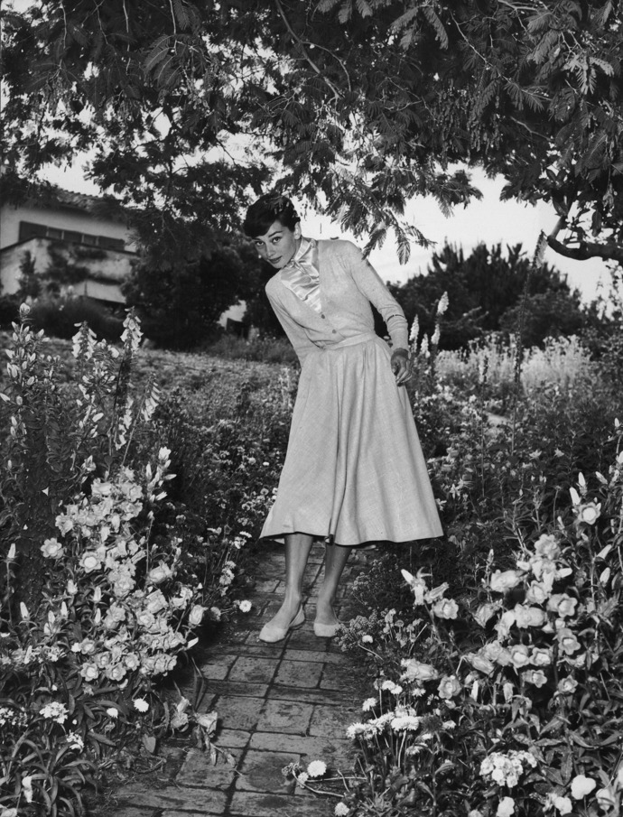 Krásná a šik Audery Hepburn v zahradě. 

