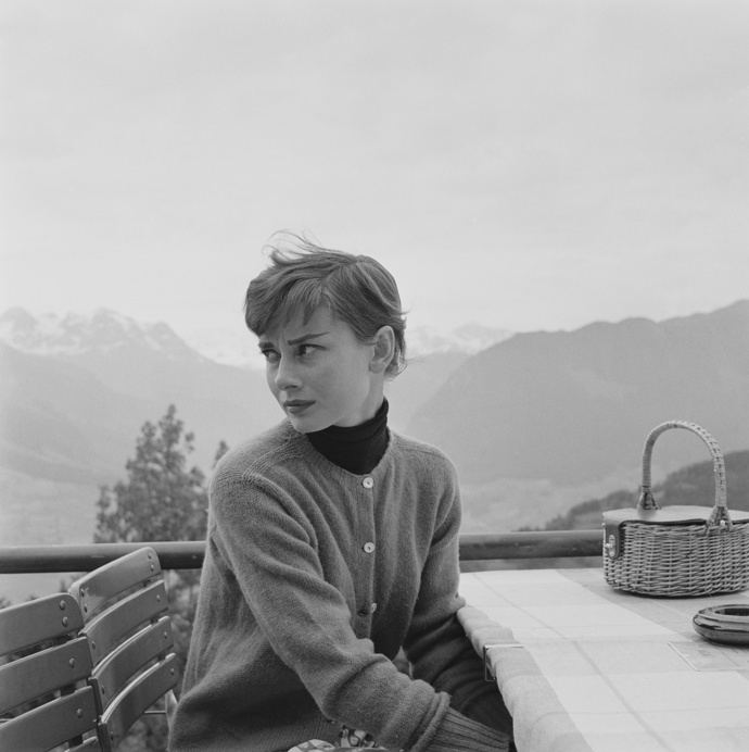 Audrey Hepburn na terase restaurace ve Švýcarsku v roláku, které nosila tak ráda. 
