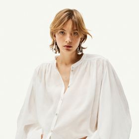 Bílá košile z tkaniny ramie s balonovým rukávem. Značka H&M, přibližná cena 719 Kč. Během Dnů Marianne platí sleva 20 % při nákupu nad 800 Kč.
