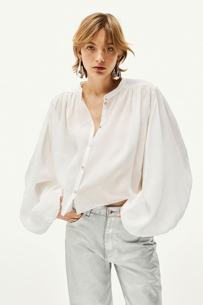 Bílá košile z tkaniny ramie s balonovým rukávem. Značka H&M, přibližná cena 719 Kč. Během Dnů Marianne platí sleva 20 % při nákupu nad 800 Kč.
