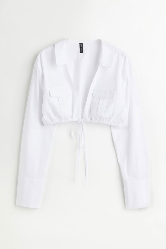 Zkrácená bílá košile z tkané látky. Má límec a hluboký průstřih do véčka se stahovací šňůrkou v dolním lemu. Značka H&M,, přibližná cena 599 Kč. Během Dnů Marianne platí sleva 20 % při nákupu nad 800 Kč. 
