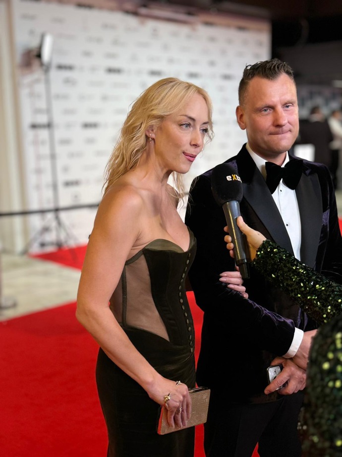 Kateřina Mátlová si na červený koberec oblékla dlouhé černé šaty bez ramínek korzetového typu, s průsvitnou látkou po stranách, jež byly ozvláštněny detaily v podobě knoflíků.
