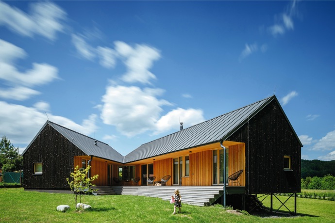 „Přestože šlo o poměrně velkou parcelu, 2162 m2, zastavitelná byla jen její část,“ říká architekt Václav Kocián. „Ochranné pásmo lesa a obecní plynové zásobníky, které sice nejsou přímo pod pozemkem, ale dům od nich musí být 80 metrů daleko, v podstatě vyřešily jak jeho umístění, tak i tvar. Zároveň Lucie s Lukášem chtěli mít v domě vyčleněnou část pro hosty, kterou by později případně mohli proměnit na ‚vejminek‘ pro své rodiče,“ doplňuje.
