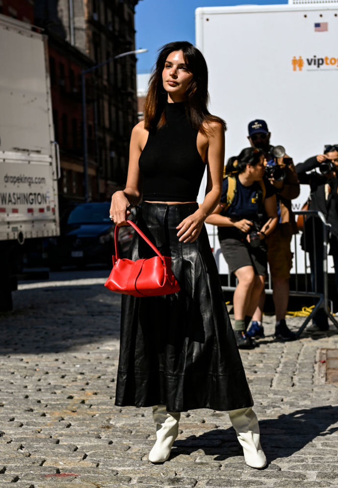 Červené doplňky a dlouhé sukně jsou aktuálně velkými trendy, Emily Ratajkowski je efektně zkombinovala do jednoho outfitu a přidala bílé kozačky.
