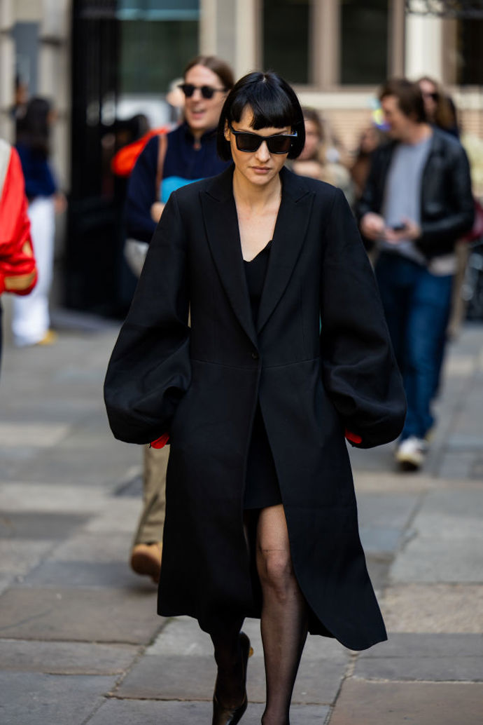 Černý kabát s objemnými rukávy ozvláštní každý outfit.
