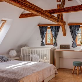 Interiér je promyšlenou kombinací nábytku na míru, který dominuje v podkrovní ložnici, a starších prvků, které dodávají charakter ložnici v prvním patře.
