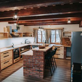 Dominantním prvkem kuchyně je elegantní cihlový bar, který přidává místnosti rustikální nádech.
