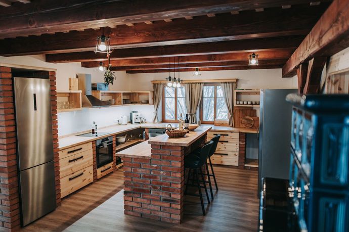 Dominantním prvkem kuchyně je elegantní cihlový bar, který přidává místnosti rustikální nádech.
