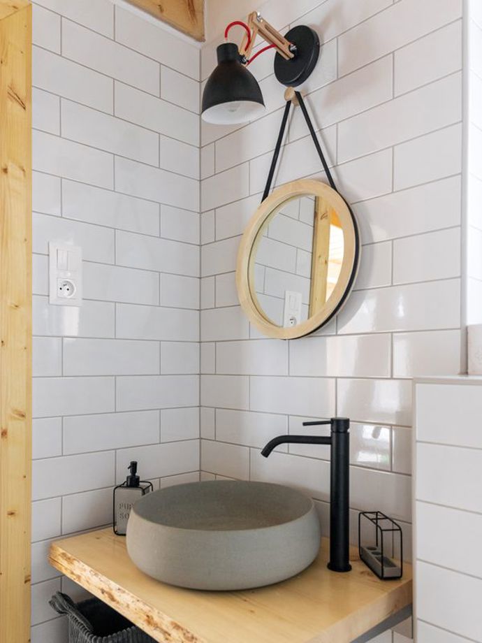 Koupelna je moderně zařízená s čistými liniemi, obsahuje prostorný sprchový kout a přírodní prvky, které ladí s celkovým designem chaty.
