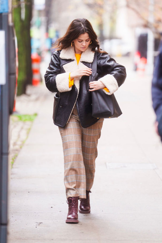 Selena Gomez oblékla shearling bundu ke kostkovaným kalhotám a šněrovacím botám.
