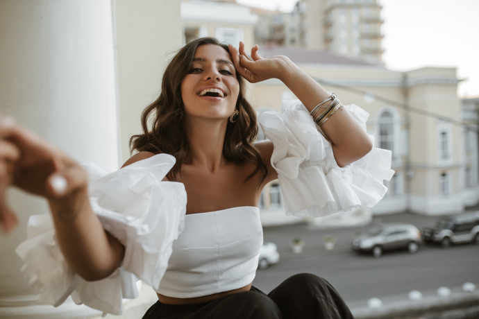 Bílá volánová halenka a černé společenské kalhoty tvoří elegantní a zároveň nápaditý model do společnosti. 
