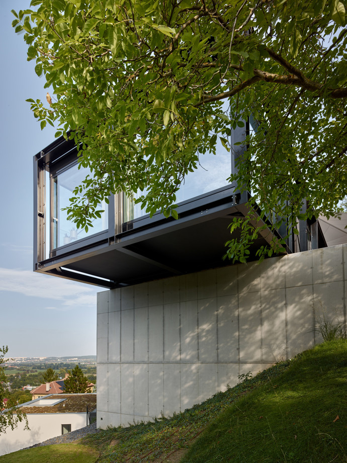V malebné vilové čtvrti nad Berounkou vyrostla moderní vila Sidonius, která redefinuje pojetí luxusního bydlení. Postavená na prudkém svahu pomocí ocelové mostní konstrukce, nabízí obyvatelům nejen výhledy na krásy Českého krasu a Prahu, ale také originální architektonické a technologické řešení.

