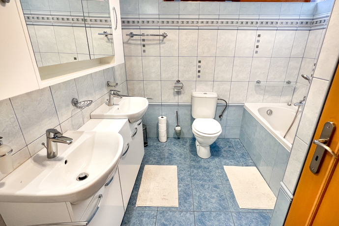 Rodinný dům disponuje dvěma plně oddělenými byty, každý s vlastním vstupem, terasou, koupelnou a kuchyní. Je to ideální místo k vícegeneračnímu bydlení. Celý interiér působí svěže, útulně a přívětivě. Převládá v něm dřevo a světlé barvy.
