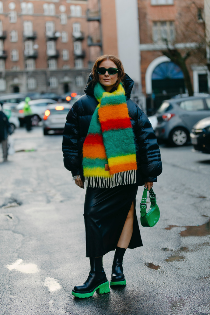 Celočerný outfit s puffer bundou rozsvítíte barevnými doplňky, jako je pruhovaná šála nebo zářivě zelená kabelka.
