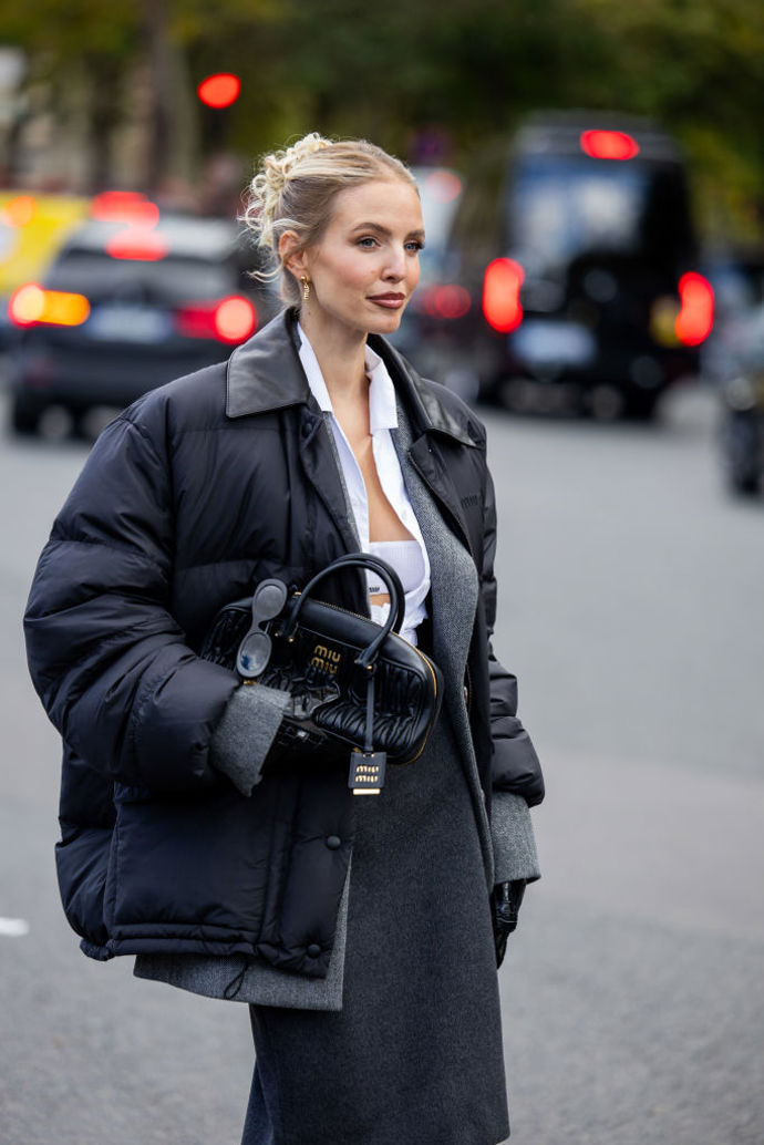 Influencerka Leonie Hanne navrstvila černou puffer bundu Miu Miu s šedým sakem a bílou košilí.
