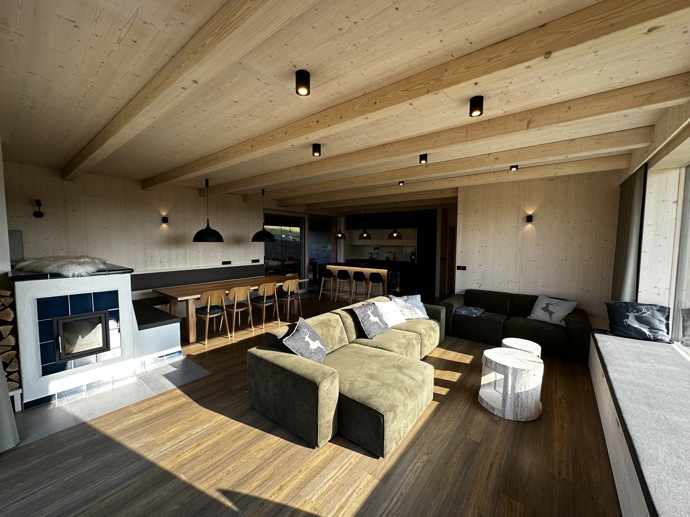 Přírodní minimalistický design a decentní barevná paleta zajišťuje dokonalou eleganci. Velkými okny proudí dovnitř mnoho světla, přes které je možné pozorovat malebnou krajinu, která celou chatu obklopuje. Fasádu domu tvoří ručně štípané modřínový šindel, zatímco uvnitř je obloženo smrkovými biodeskami.
