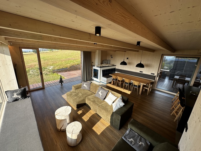 Přírodní minimalistický design a decentní barevná paleta zajišťuje dokonalou eleganci. Velkými okny proudí dovnitř mnoho světla, přes které je možné pozorovat malebnou krajinu, která celou chatu obklopuje. Fasádu domu tvoří ručně štípané modřínový šindel, zatímco uvnitř je obloženo smrkovými biodeskami.
