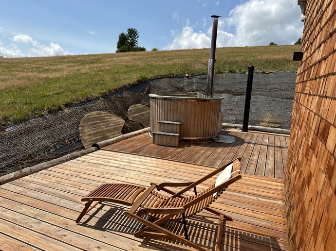 Přírodní minimalistický design a decentní barevná paleta zajišťuje dokonalou eleganci. Velkými okny proudí dovnitř mnoho světla, přes které je možné pozorovat malebnou krajinu, která celou chatu obklopuje. Fasádu domu tvoří ručně štípané modřínový šindel, zatímco uvnitř je obloženo smrkovými biodeskami.
