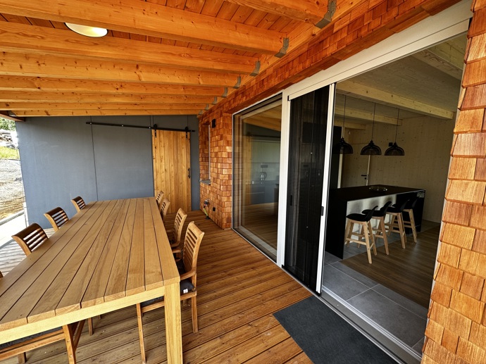 Přírodní minimalistický design a decentní barevná paleta zajišťuje dokonalou eleganci. Velkými okny proudí dovnitř mnoho světla, přes které je možné pozorovat malebnou krajinu, která celou chatu obklopuje. Fasádu domu tvoří ručně štípané modřínový šindel, zatímco uvnitř je obloženo smrkovými biodeskami.
