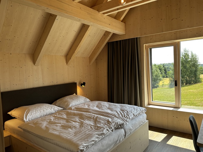 Přírodní minimalistický design a decentní barevná paleta zajišťuje dokonalou eleganci. Velkými okny proudí dovnitř mnoho světla, přes které je možné pozorovat malebnou krajinu, která celou chatu obklopuje. Fasádu domu tvoří ručně štípané modřínový šindel, zatímco uvnitř je obloženo smrkovými biodeskami.
