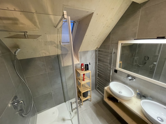 Přírodní minimalistický design a decentní barevná paleta zajišťuje dokonalou eleganci. Velkými okny proudí dovnitř mnoho světla, přes které je možné pozorovat malebnou krajinu, která celou chatu obklopuje. Fasádu domu tvoří ručně štípané modřínový šindel, zatímco uvnitř je obloženo smrkovými biodeskami.
