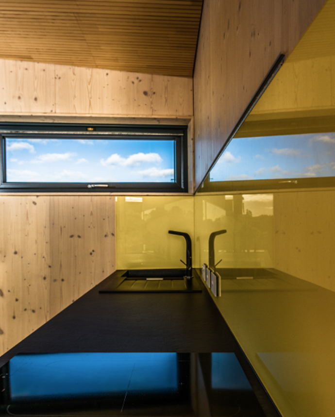 Víkendový dům je dokonalým příkladem udržitelného bydlení s minimalistickou architekturou, která zde nechává vyniknout krásu přírody, zatímco chytrý design poskytuje maximální komfort. 
