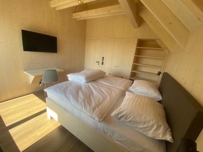Přírodní minimalistický design a decentní barevná paleta zajišťuje dokonalou eleganci. Velkými okny proudí dovnitř mnoho světla, přes které je možné pozorovat malebnou krajinu, která celou chatu obklopuje. Fasádu domu tvoří ručně štípané modřínový šindel, zatímco uvnitř je obloženo smrkovými biodeskami.
