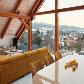 Majestátní Ještěd se nestal jen výhledem z okna, ale inspirací pro celý interiér. Architektka Taťána Kandratovičová vytvořila prostor, kde se moderní design prolíná s přírodními materiály a tradicí roubených staveb.
