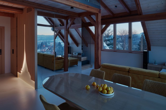 Majestátní Ještěd se nestal jen výhledem z okna, ale inspirací pro celý interiér. Architektka Taťána Kandratovičová vytvořila prostor, kde se moderní design prolíná s přírodními materiály a tradicí roubených staveb.
