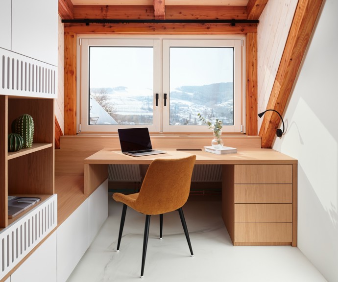 Majestátní Ještěd se nestal jen výhledem z okna, ale inspirací pro celý interiér. Architektka Taťána Kandratovičová vytvořila prostor, kde se moderní design prolíná s přírodními materiály a tradicí roubených staveb.
