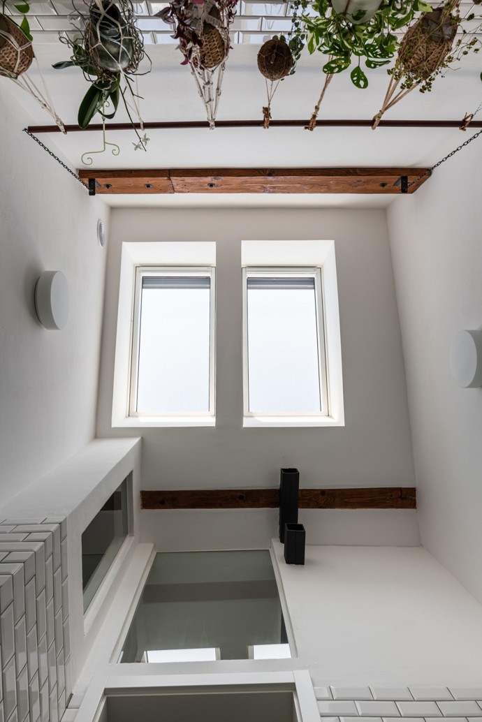 Tento bratislavský byt vznikl doslova v srdci podkroví historického domu, kde architekti využili komíny jako funkční prvek a přidali útulnou lavici u krbu. Nechybí tu světlík, balkón a chytré úložné prostory. Architekti přetvořili nevyužitý prostor v útulné bydlení pro mladou rodinu.
