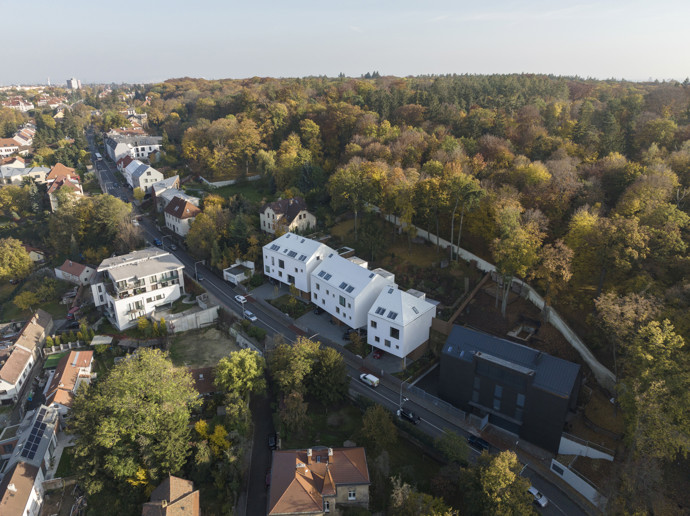 Obytný soubor v pražské Liboci tvoří tři objekty: rodinná vila investora, bytový dům o čtyřech jednotkách a menší rodinný dům. Cílem bylo minimalistickou formou doplnit vesnickou strukturu a reagovat na specifický pozemek se skálou.
