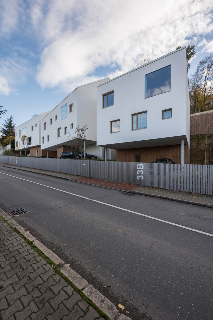Obytný soubor v pražské Liboci tvoří tři objekty: rodinná vila investora, bytový dům o čtyřech jednotkách a menší rodinný dům. Cílem bylo minimalistickou formou doplnit vesnickou strukturu a reagovat na specifický pozemek se skálou.
