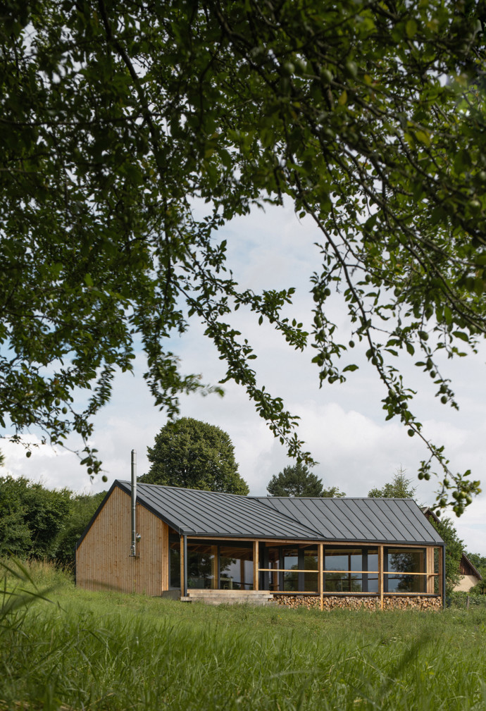 Na kraji Hrubé Skály vyrostl víkendový dům, který přirozeně zapadá do krajiny Českého ráje. Citlivě kombinuje tradiční prvky s moderní architekturou a nabízí klidné místo k odpočinku s výhledem na zříceninu hradu Trosky.
