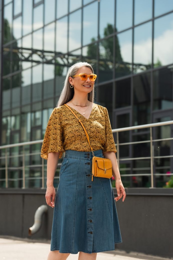 Denimová sukně s knoflíky je oblíbeným kouskem letošního jara. Sluší i ženám nad 50 let. Džínovina elegantně skrývá případné nedostatky a současně působí velmi mladistvě. Knoflíky dodávají sukni na zajímavosti. 
