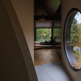 Architekti z Moguang Studio postavili mezi stromy chatu, která neruší, ale přirozeně splyne s lesem. Dům stojí na pilířích, aby nepoškodil kořeny starých stromů, a místo klasických oken má geometrické výřezy, které rámují krajinu.
