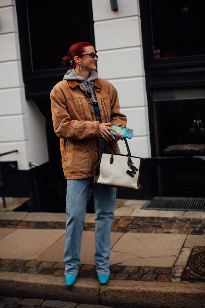 Hnědá workwear bunda v retro vzhledu se hodí ke světle modrým džínům.
