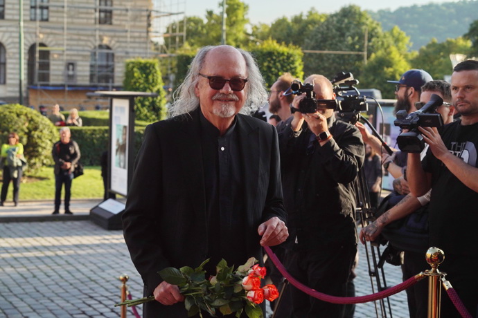 Aleš Hejma byl nadmíru elegantní a moc mu to slušelo. Celý v tmavém, s kyticí růží. Ostatně rudé růže mezi pozvanými hrály prim.
