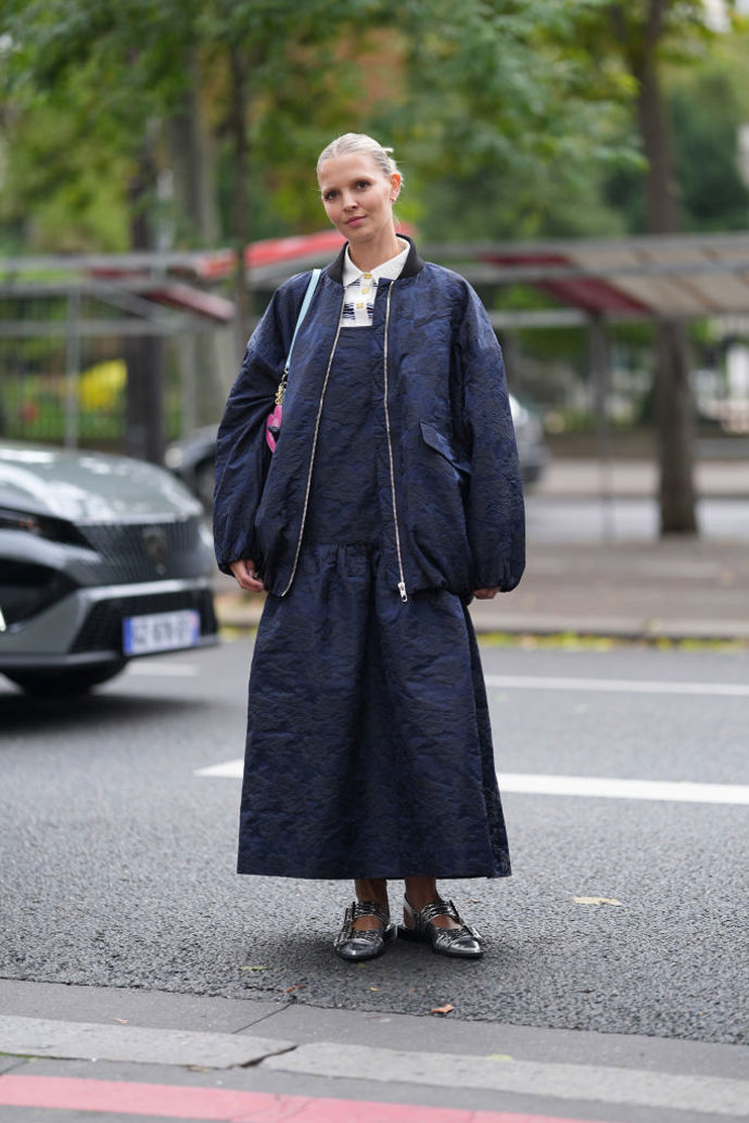Možná je vám blízké kombinování sportovnějších a elegantnějších prvků v duchu skandinávského stylu, zvolte tedy tmavě modrou bundu sladěnou se šaty a obujte zářivé stříbrné boty třeba od značky Ganni.

