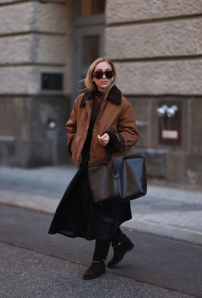 Sonia Lyson k hnědé workwear bundě přidala elegantní kousky jako kozačky a černou midi sukni.

