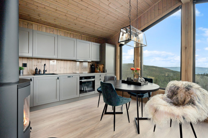 Uvnitř vás přivítá útulný, ale moderní interiér, ve kterém se snoubí skandinávský design, přírodní materiály, krbová kamna a panoramatické okna, která vám nabídnou dechberoucí výhledy na hluboké lesy a horu Gaustatoppen.
