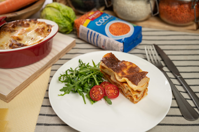 Lasagně s čočkovým ragú
4 porce
Postup
Čočku červenou vložíme do vroucí vody a uvaříme podle návodu na obalu. Na pánvi rozehřejeme máslo se lžičkou oleje, zaprášíme hladkou moukou a vytvoříme světlou jíšku. Zalijeme mlékem, nastrouháme kousek muškátového oříšku, přimícháme nastrouhaný parmezán a provaříme. Na druhé pánvi na rozehřátém oleji zesklovatíme nadrobno nakrájenou cibuli a česnek. Mrkev a celer očistíme, nakrájíme na kostičky a přidáme do pánve. Přisypeme cukr a necháme zkaramelizovat. Přidáme drcená rajčata, uvařenou čočku, tymián a vše společně podusíme, případně dochutíme. Do pekáčku s pečicím papírem dáme část bešamelové omáčky, na ni rozprostřeme část lasagní a čočkového ragú. Takto vrstvíme dál, poslední vrstvu tvoří bešamelová omáčka. Vložíme do trouby předehřáté na 145 °C a pečeme cca 1 hodinu. Servírujeme posypané čerstvou rukolou.
Lasagně s čočkovým ragú
4 porce
Postup
Čočku červenou vložíme do vroucí vody a uvaříme podle návodu na obalu. Na pánvi rozehřejeme máslo se lžičkou oleje, zaprášíme hladkou moukou a vytvoříme světlou jíšku. Zalijeme mlékem, nastrouháme kousek muškátového oříšku, přimícháme nastrouhaný parmezán a provaříme. Na druhé pánvi na rozehřátém oleji zesklovatíme nadrobno nakrájenou cibuli a česnek. Mrkev a celer očistíme, nakrájíme na kostičky a přidáme do pánve. Přisypeme cukr a necháme zkaramelizovat. Přidáme drcená rajčata, uvařenou čočku, tymián a vše společně podusíme, případně dochutíme. Do pekáčku s pečicím papírem dáme část bešamelové omáčky, na ni rozprostřeme část lasagní a čočkového ragú. Takto vrstvíme dál, poslední vrstvu tvoří bešamelová omáčka. Vložíme do trouby předehřáté na 145 °C a pečeme cca 1 hodinu. Servírujeme posypané čerstvou rukolou.