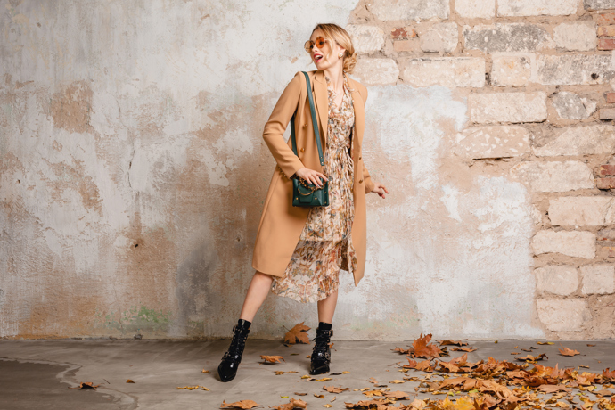 Dlouhý hnědý kardigan je skvělým příkladem vrstvení, které dokáže proměnit letní šaty v podzimní outfit. Neutrální květinový vzor působí jemně a přitom zůstává nadčasový. Nízké černé kozačky dodávají celku šmrnc a zajišťují pohodlí při chůzi. Outfit působí ležérně, ale přesto elegantně. Toto je důkaz, že ani oblíbené letní kousky nemusí zůstat na dně skříně.
